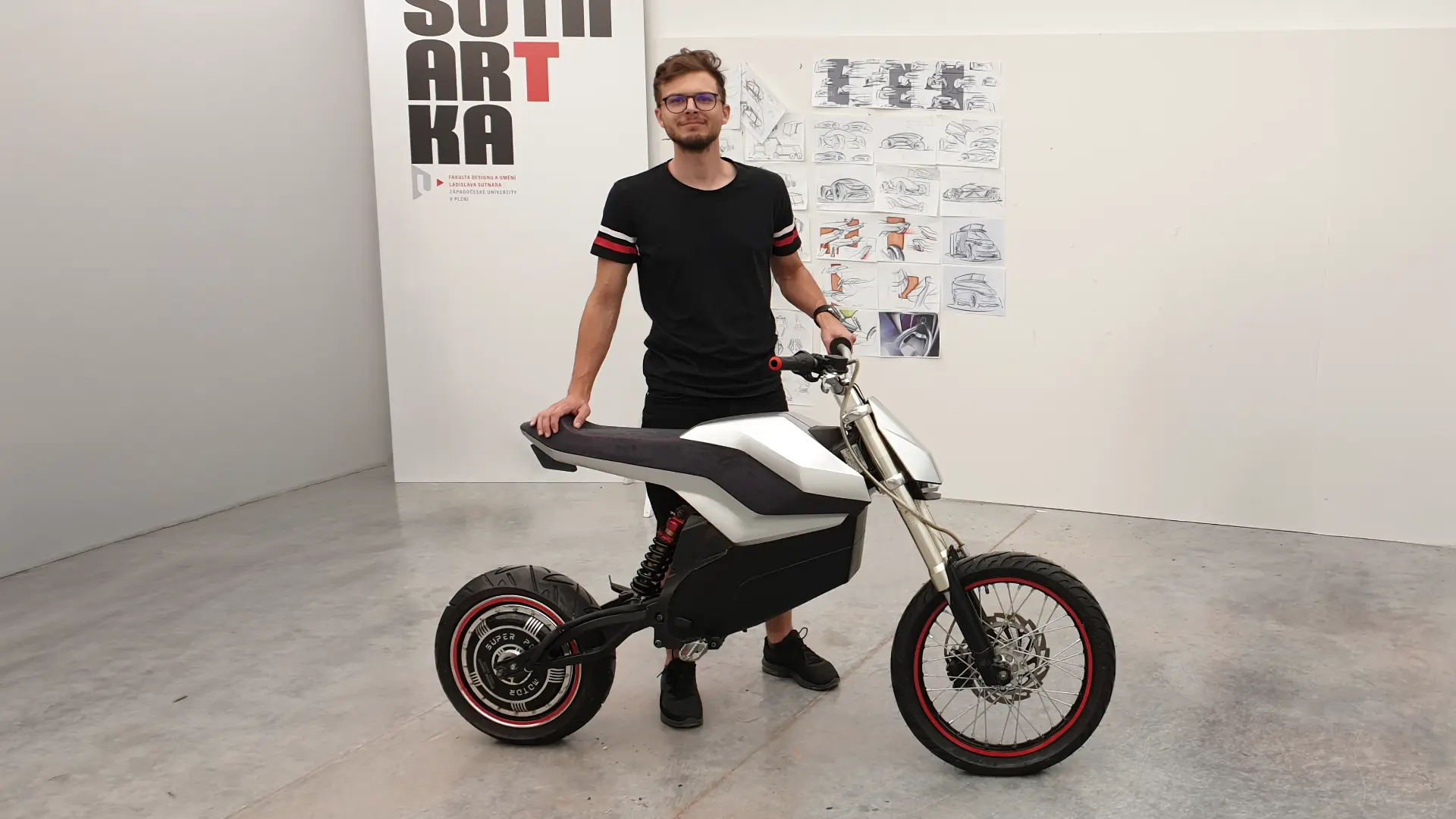 Finished full-scale E-moto prototype next to the designer in the studio