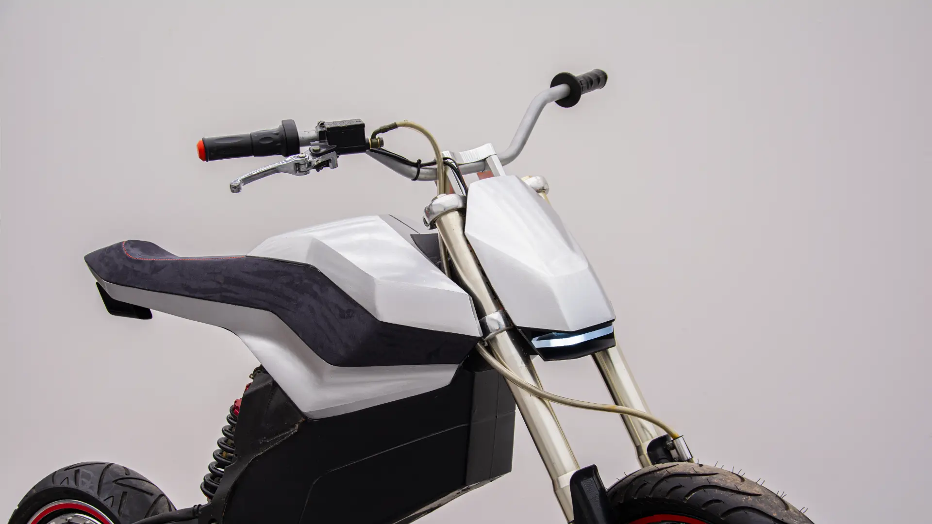 Front three-quarter view of the E-moto prototype showing the cockpit, seat and front fairing