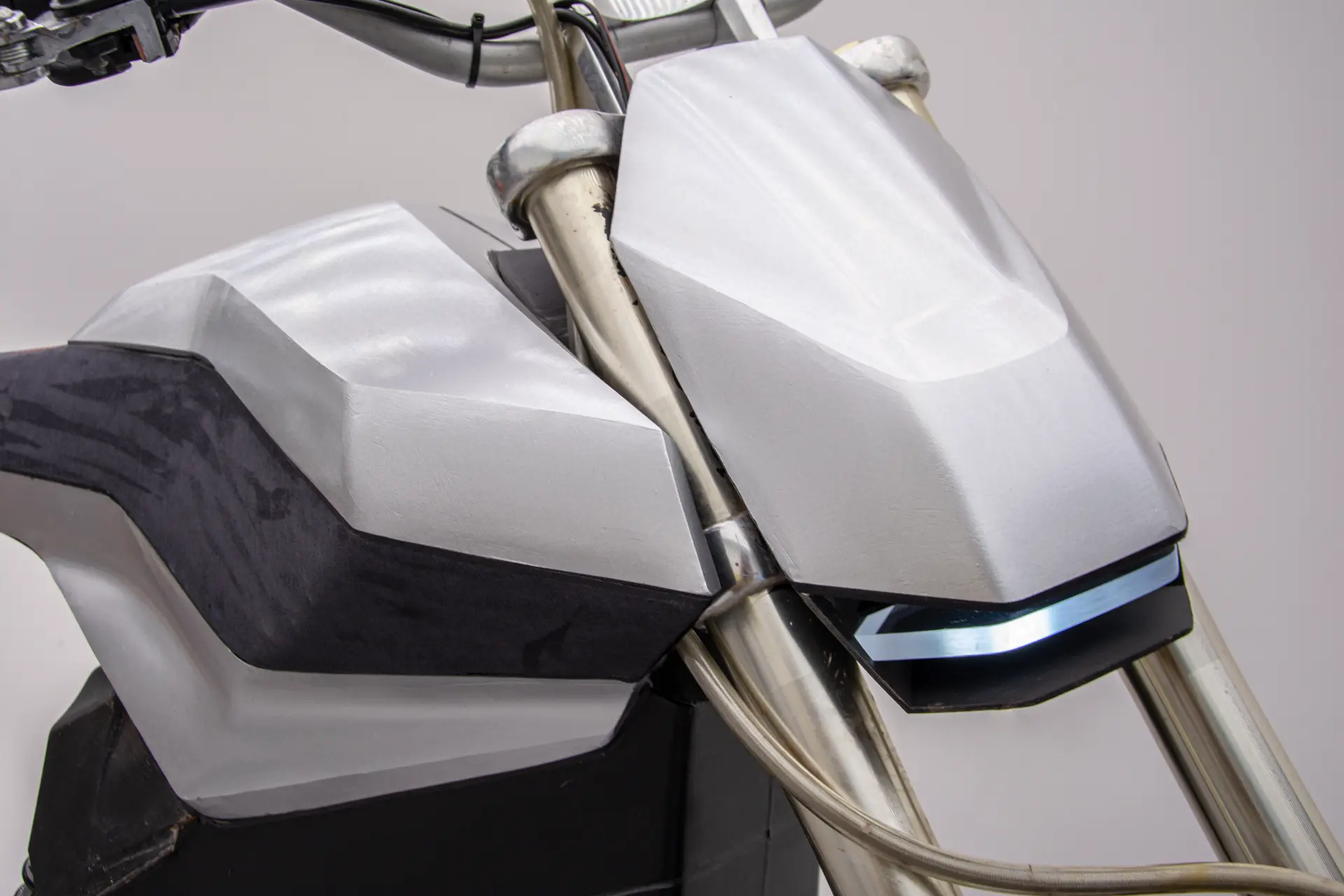 Close-up of the E-moto headlight and front body panel surfacing